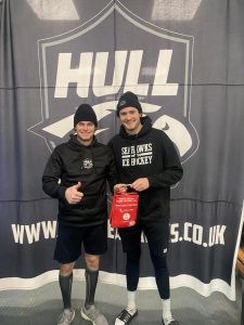 Two ice hockey players from the Hull Seahawks team holding a Daniel Baird Bleed Control Kit donated by money raised by Adam's Angels.