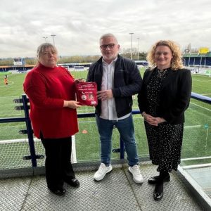 Julie Taylor and Councillor McKinlay hand over a Daniel Baird Foundation bleed kit to Billericay Town FC's Managing Director, Alex Morrissey.