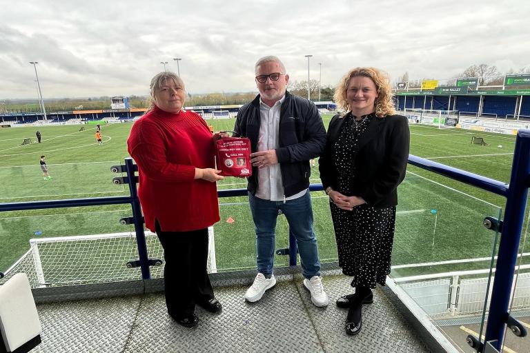 Julie Taylor and Councillor McKinlay hand over a Daniel Baird Foundation bleed kit to Billericay Town FC's Managing Director, Alex Morrissey.