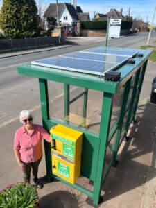 Margaret Harford, Creswell Parish Council’s Chairperson standing next to the first ever solar powered defibrillator cabinet integrated on a bus shelter, designed by Turtle Medical