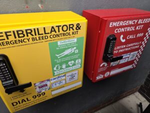 Yellow public defib cabinet on left, red bleed control cabinet on right