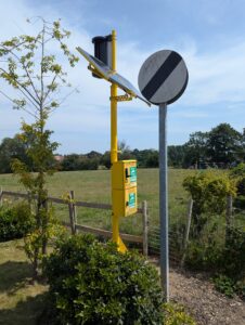 Turtle Medical wind and solar powered AED cabinet in rural village next to walking path and field