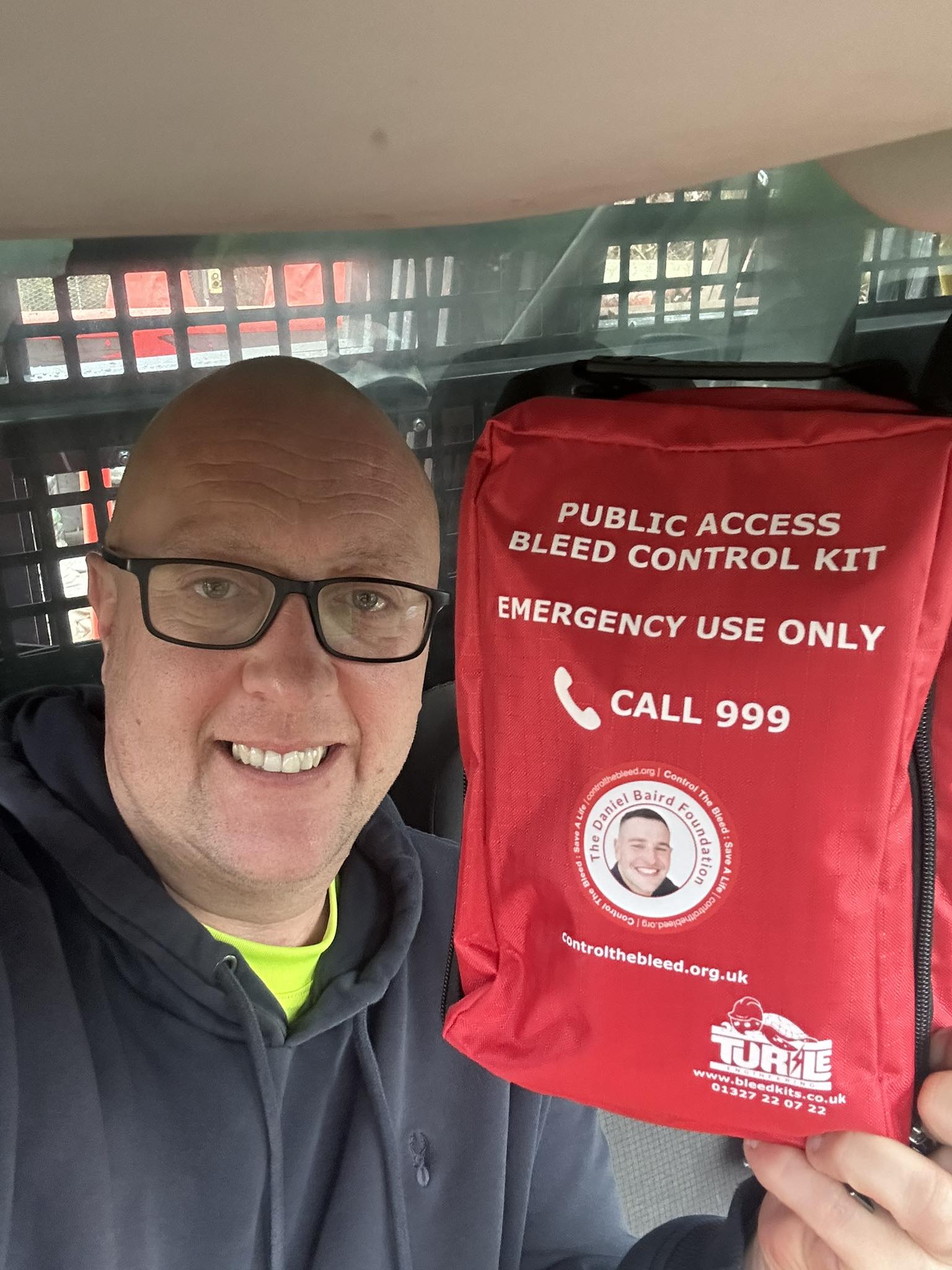 Close up of Kyle Hotchkins holding Daniel Baird bleed kit 